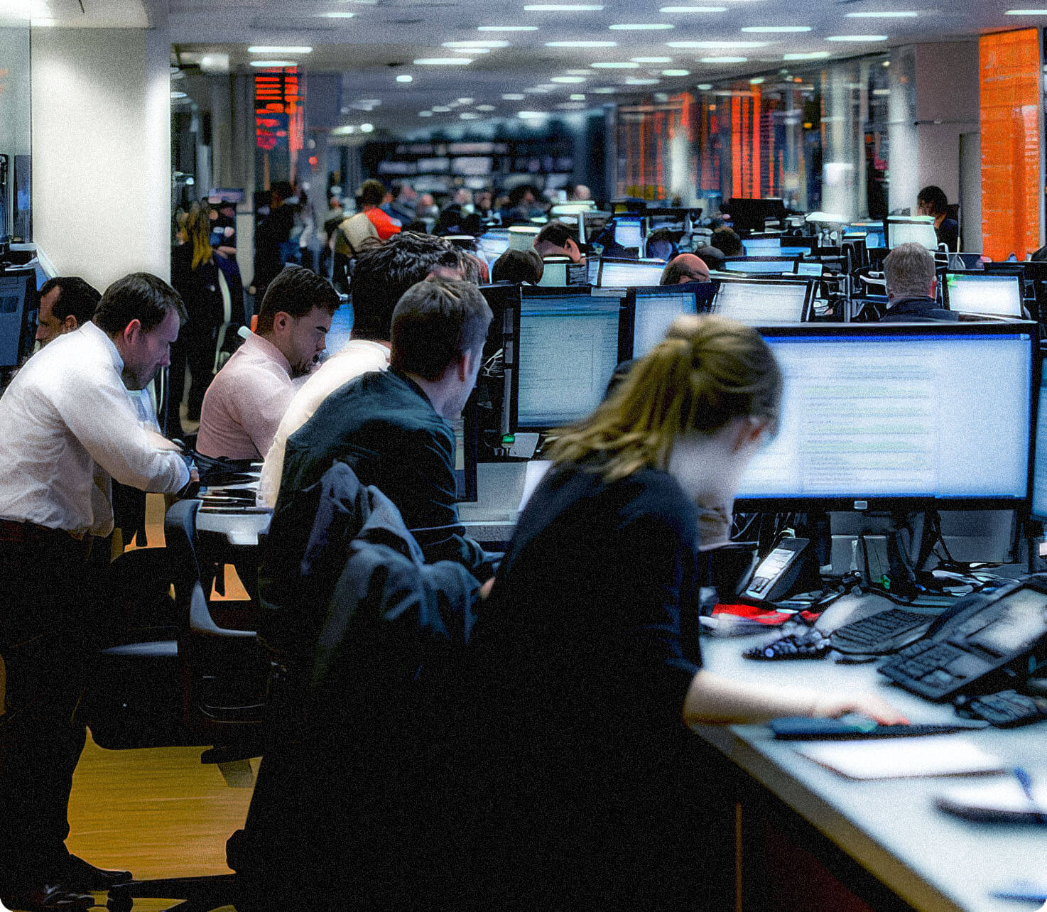 Institutional trading desk with traders working across multiple monitors.